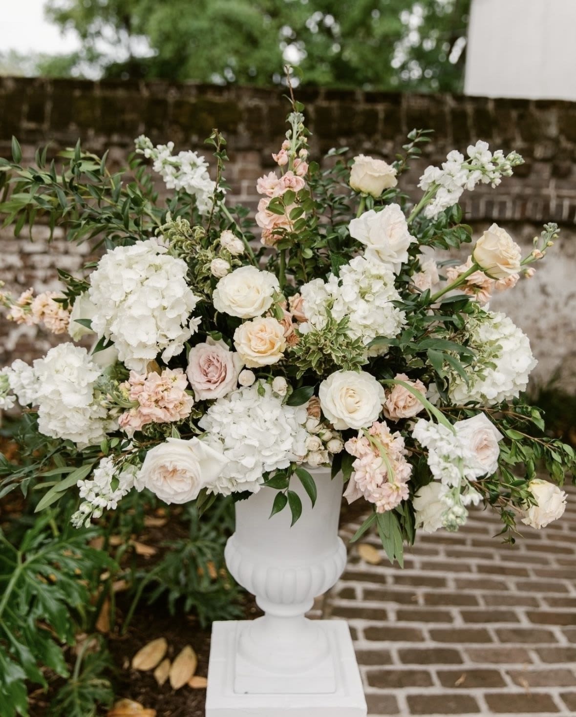 Blush garden altar arrangement  - A soft, romantic altar piece filled with creamy roses, airy hydrangeas, delicate blush blooms, and lush greenery. This arrangement feels like a garden in full bloom  elegant, light, and timeless. Perfect for ceremonies, arches, or statement corners, it adds that wow moment without overpowering the space. Gentle, dreamy, and made to feel unforgettable.