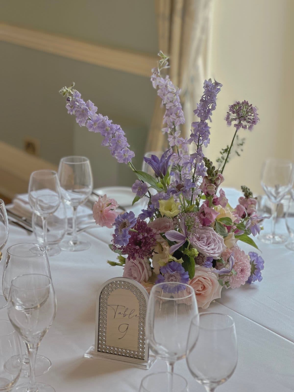 Meadow Whisper Centerpiece - An airy, garden-inspired centerpiece with soft roses, playful pastel blooms, and delicate wildflower movement. Light, romantic, and full of life — it feels like a little meadow landed on your table. Perfect for intimate dinners and weddings where you want charm without blocking conversation. Colors are fully customizable to match your palette  from dreamy pastels to bold, modern tones. Flowers may vary, but look will be the same.