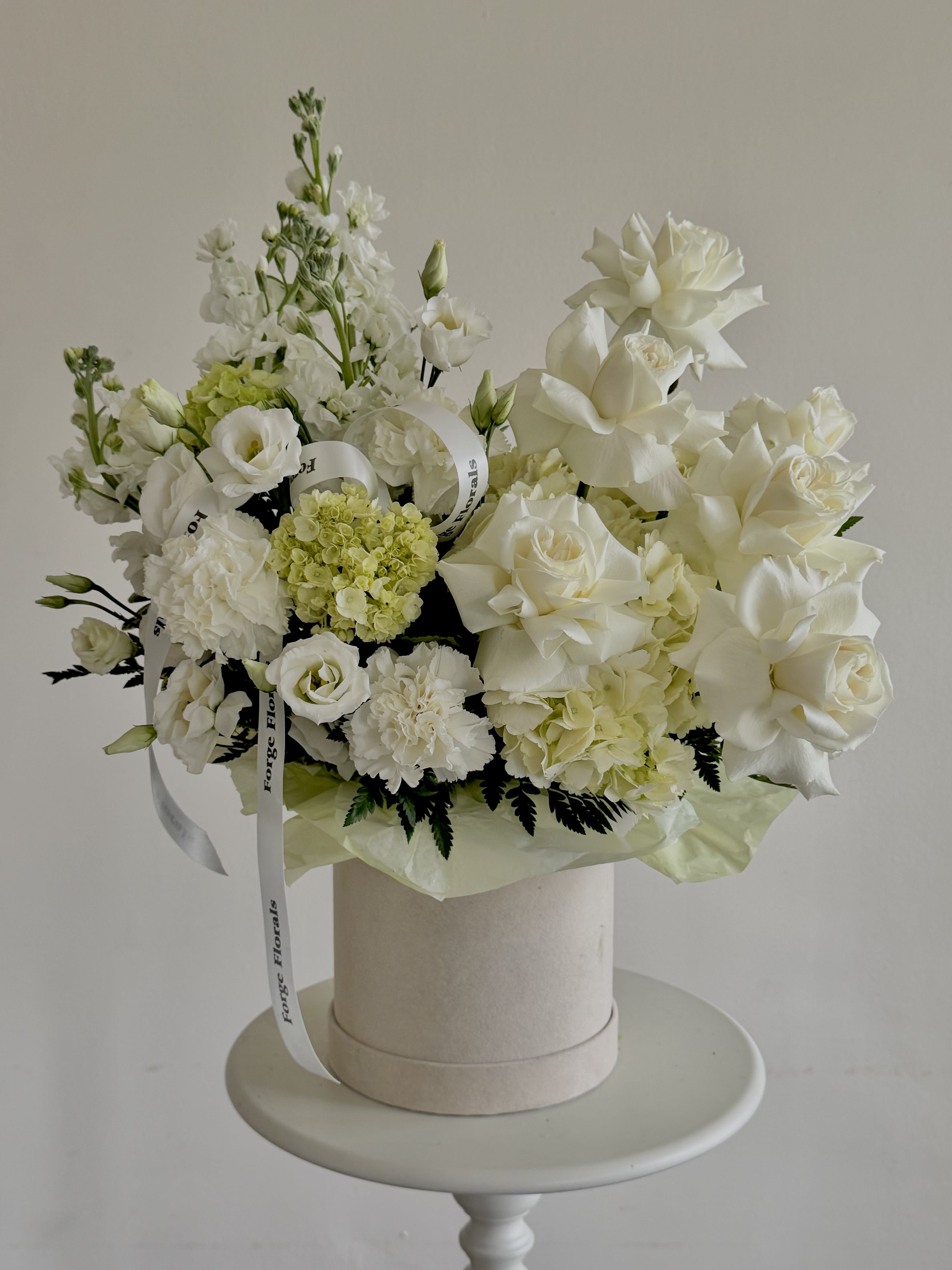Fairy green Box - A soft, sculptural design in creamy whites and fresh greens. Layered roses, airy blooms, and gentle texture create a look that feels light, modern, and effortlessly elegant  like a cloud of petals. Perfect for entrances, sweetheart tables, or statement moments where you want calm luxury without being loud.