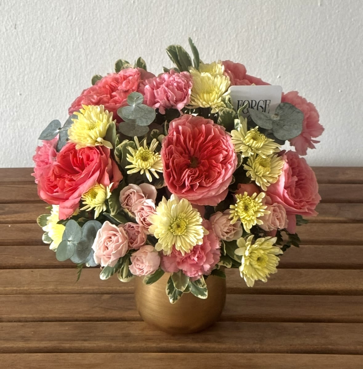 Blush &amp; Bloom- garden roses, chrysanthemum, eucalyptus - A cheerful garden-style arrangement filled with layers of soft pinks, buttery creams, and fresh greenery. Garden roses, spray roses, carnations, and chrysanthemums come together in a warm golden vase to create a design that feels romantic, joyful, and effortlessly elegant. Perfect for birthdays, thank-you gifts, celebrations, or simply brightening someone’s day.