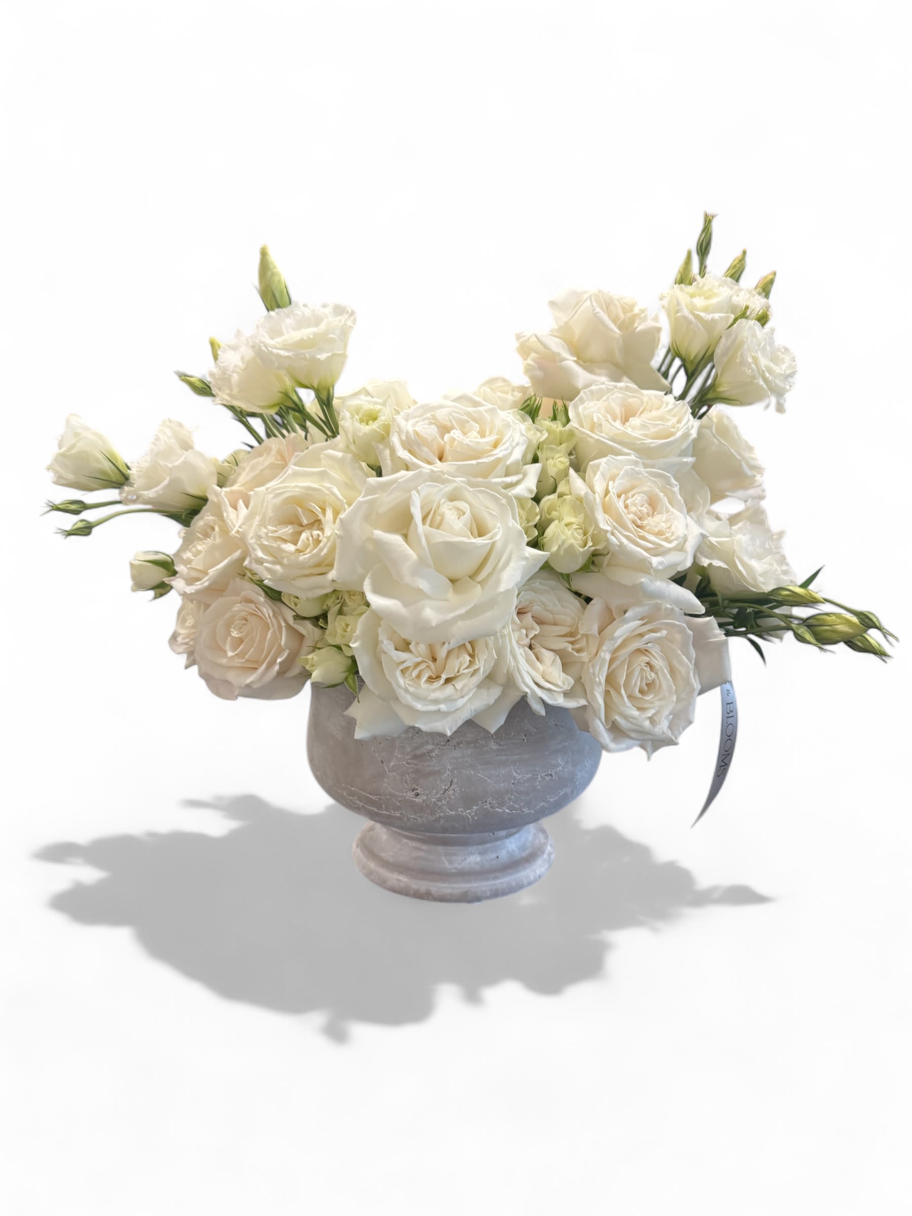 White rose bouquet in a gray pedestal vase