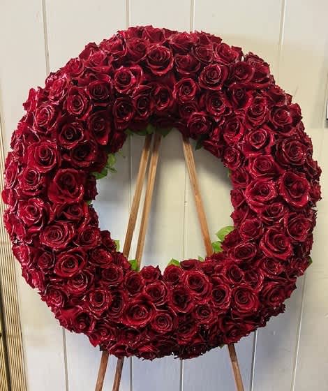Large circular wreath of red roses on a wooden easel