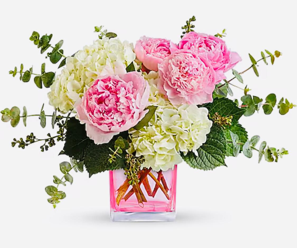 Pink peonies and white hydrangeas in a pink glass vase