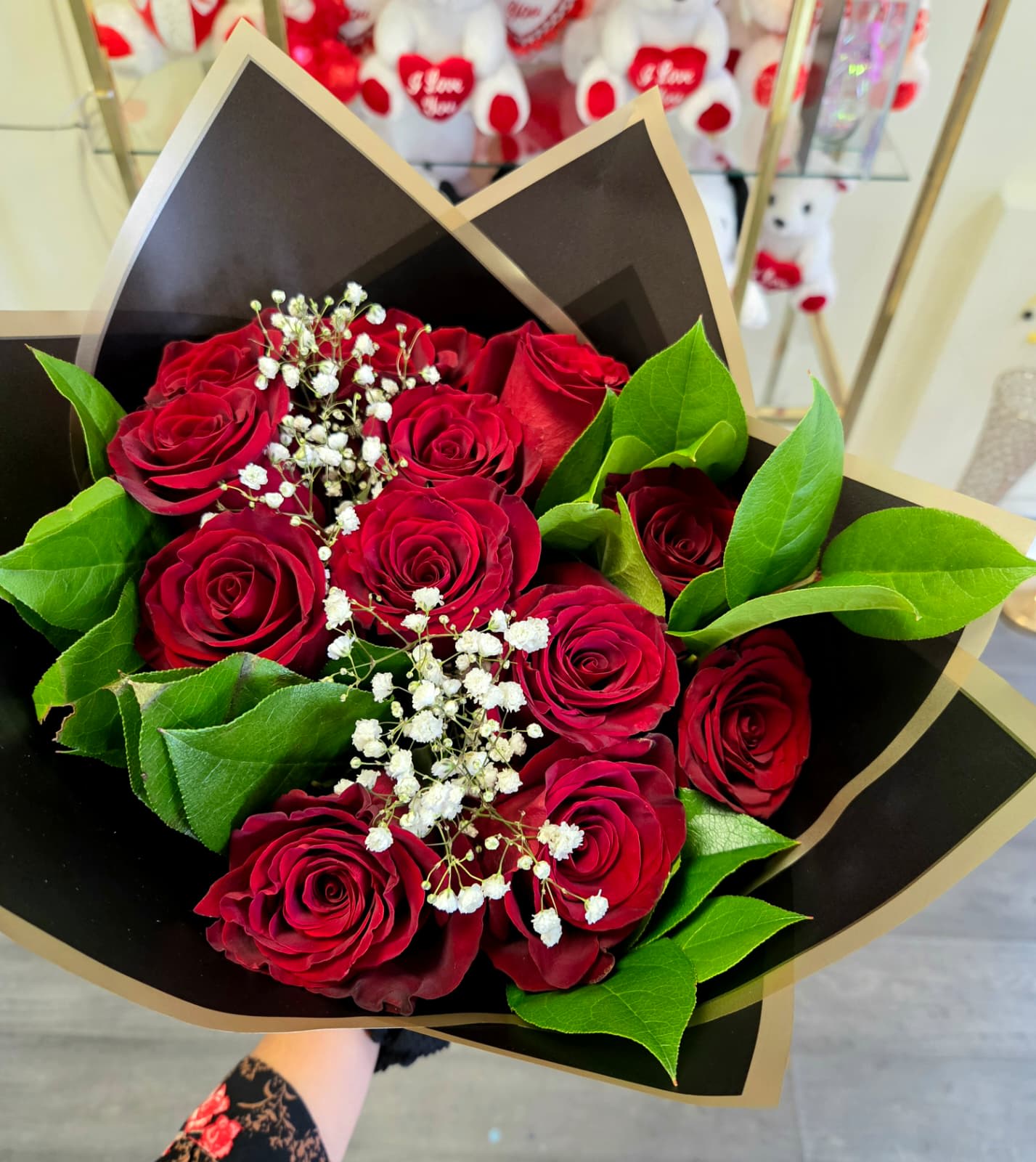 Bouquet of red roses with white baby's breath in black and gold wrap