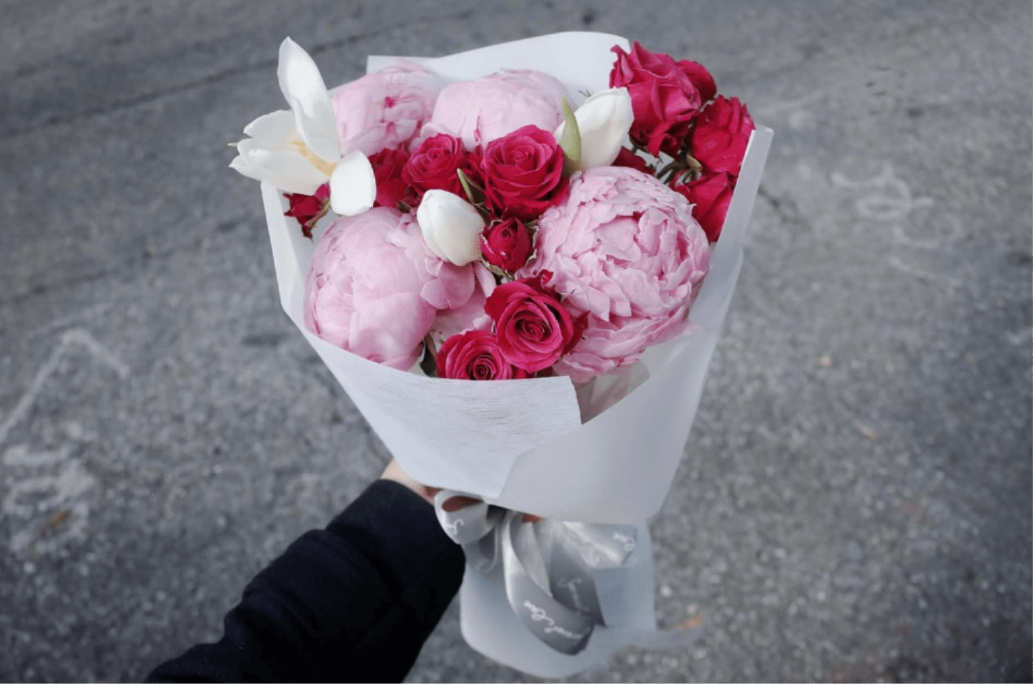 Velvet Peony Kiss - A luxurious symphony of elegance. Our Velvet Peony Kiss features premium crimson and blush peonies, symbolizing prosperity and romance. Artfully accented with white Phalaenopsis Orchids and wrapped in our signature "Cloud" style packaging.