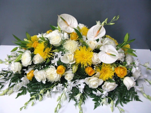 White and yellow floral arrangement with roses and anthuriums