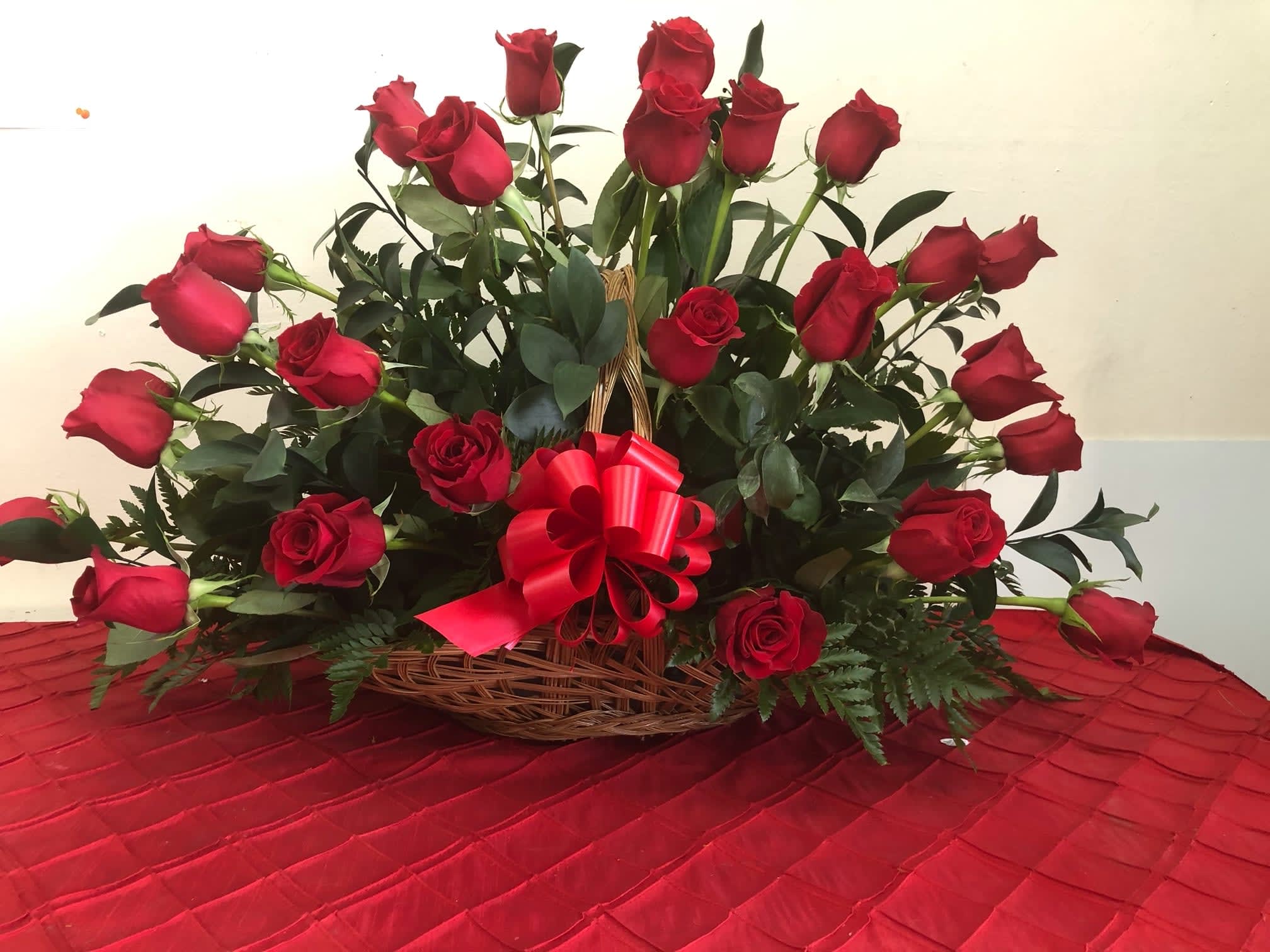 Basket of red roses with a red ribbon bow