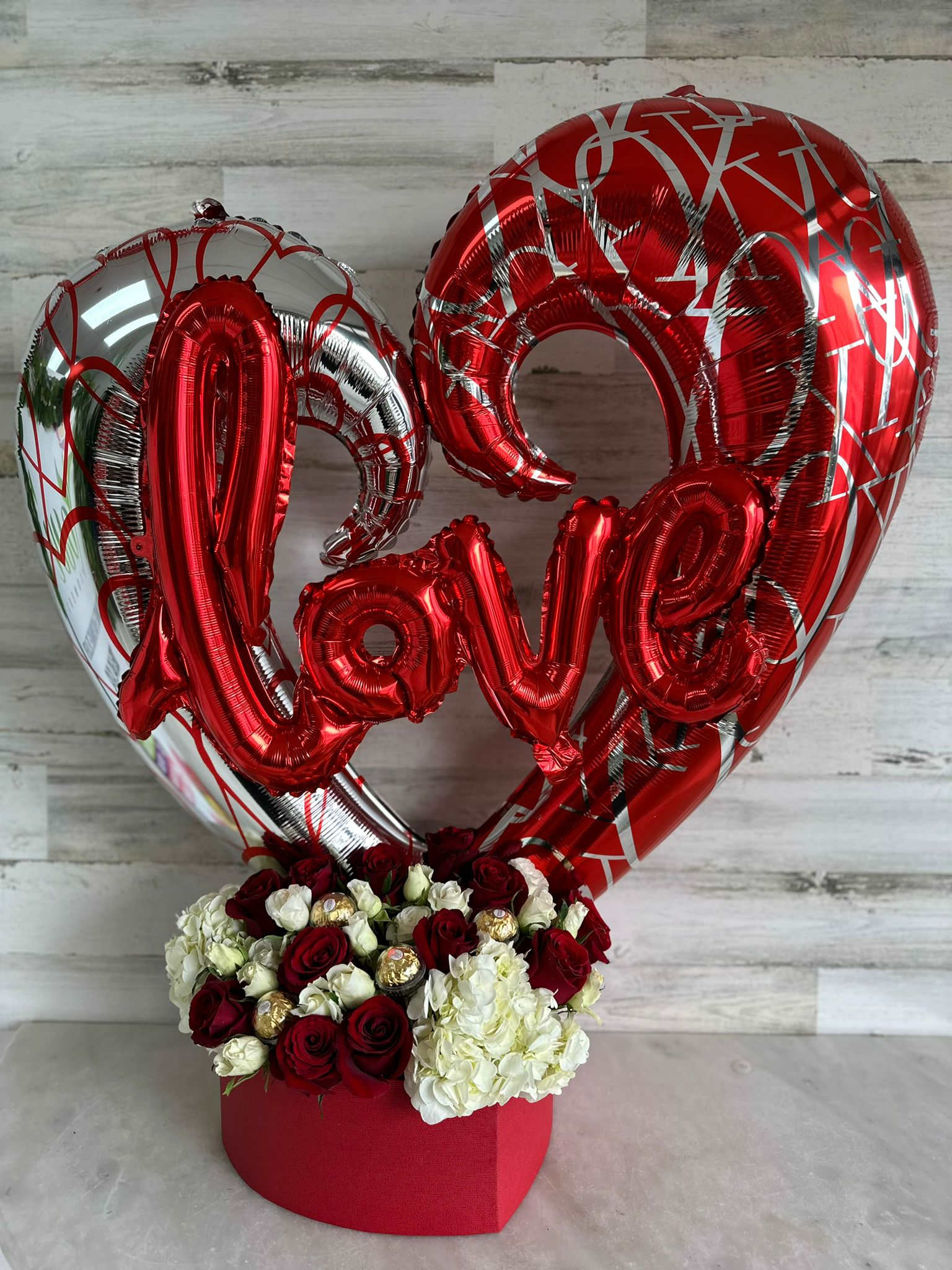 Boom Love - Modern mix of roses, spray roses and Carns in a heart shape box with a huge hear balloon and love balloon tide with the arrangement, moder, luxury and a very good-looking arrangement.