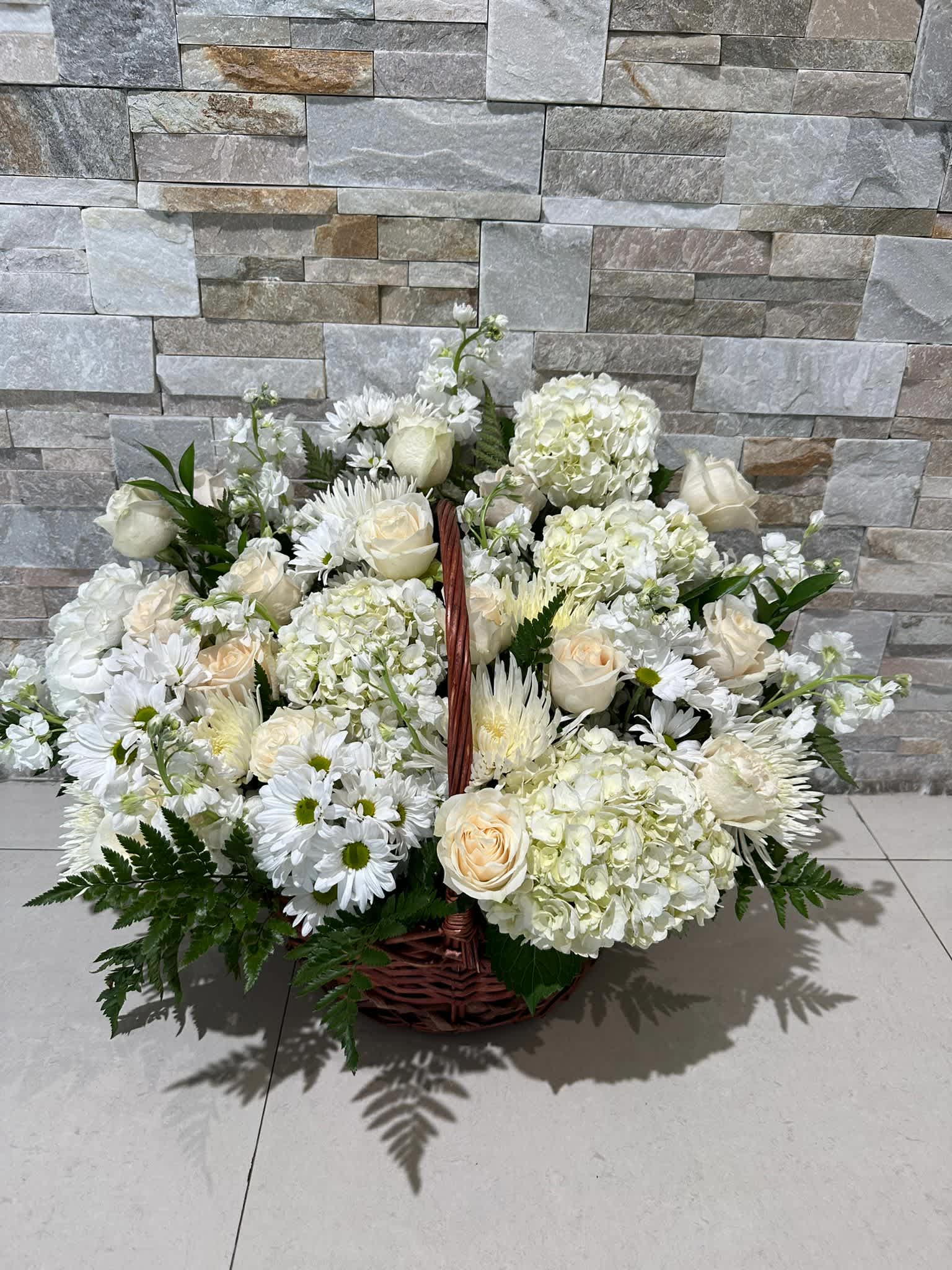 FOREVER BASKET - WHITE BASKET WITH ROSES, HYDRANGEAS AND A NICE MIX OF WHITES WITH A WICKER BASKET.