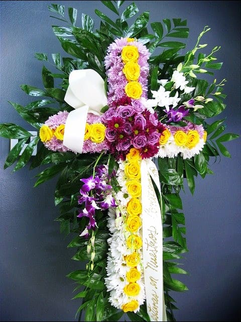 Cross-shaped floral arrangement with yellow, purple, and white flowers