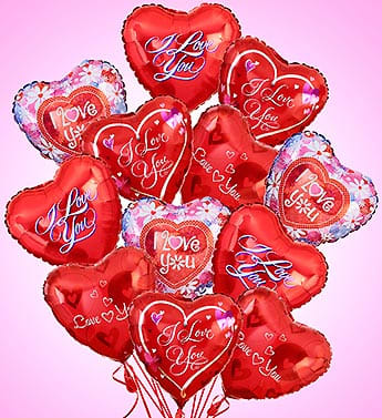 Cluster of red heart-shaped balloons with love messages on a pink background