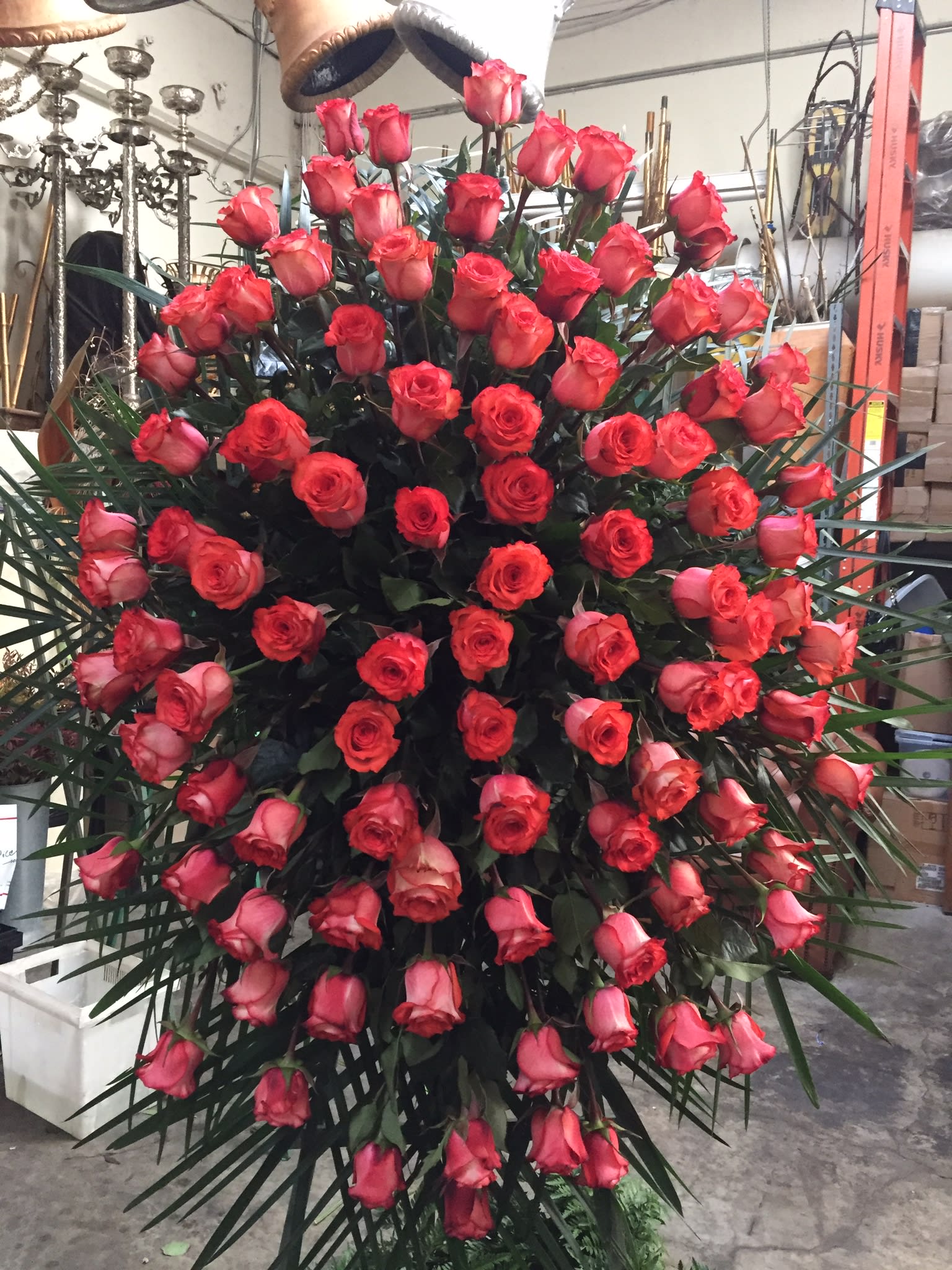 Large standing spray of red roses with palm fronds