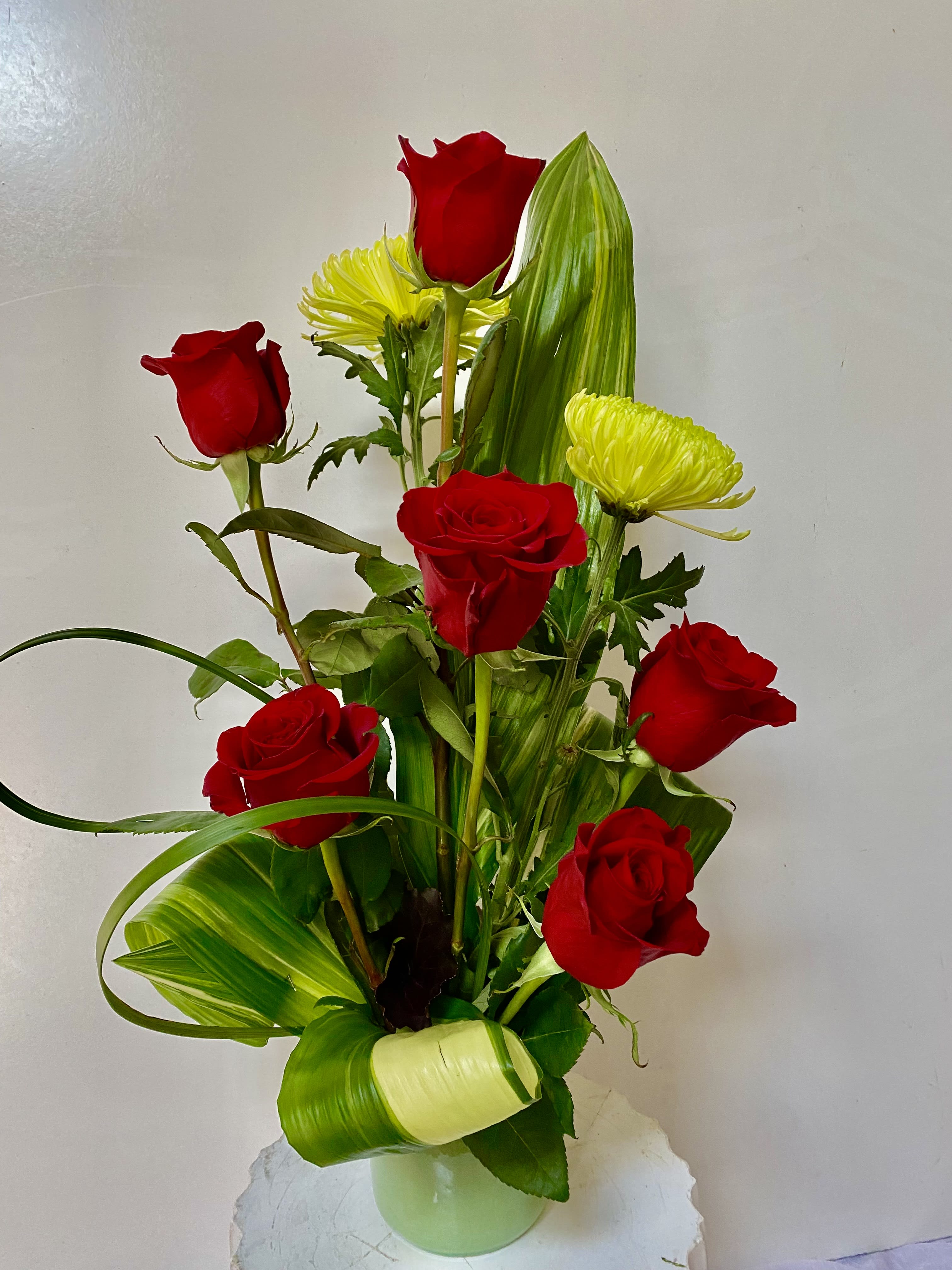 Red roses and yellow chrysanthemums in a glass vase