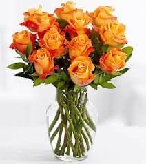 Bouquet of orange and yellow roses in a clear glass vase