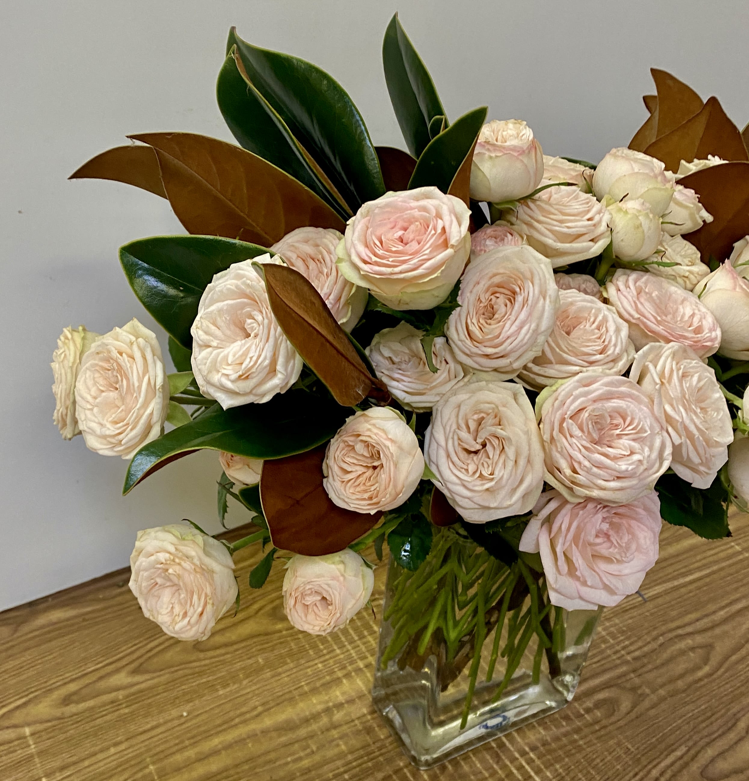 Bouquet of pale pink roses in a clear glass vase