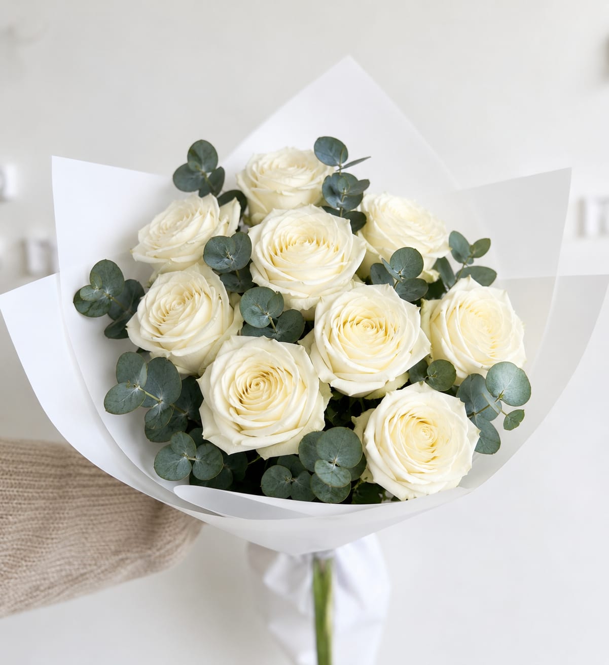 Bouquet of white roses with eucalyptus in white paper wrap