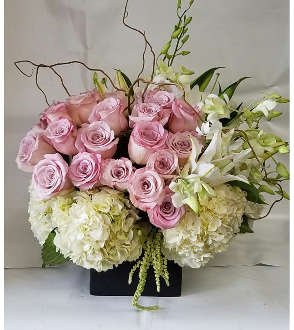 Pink roses and white hydrangeas in a black rectangular vase