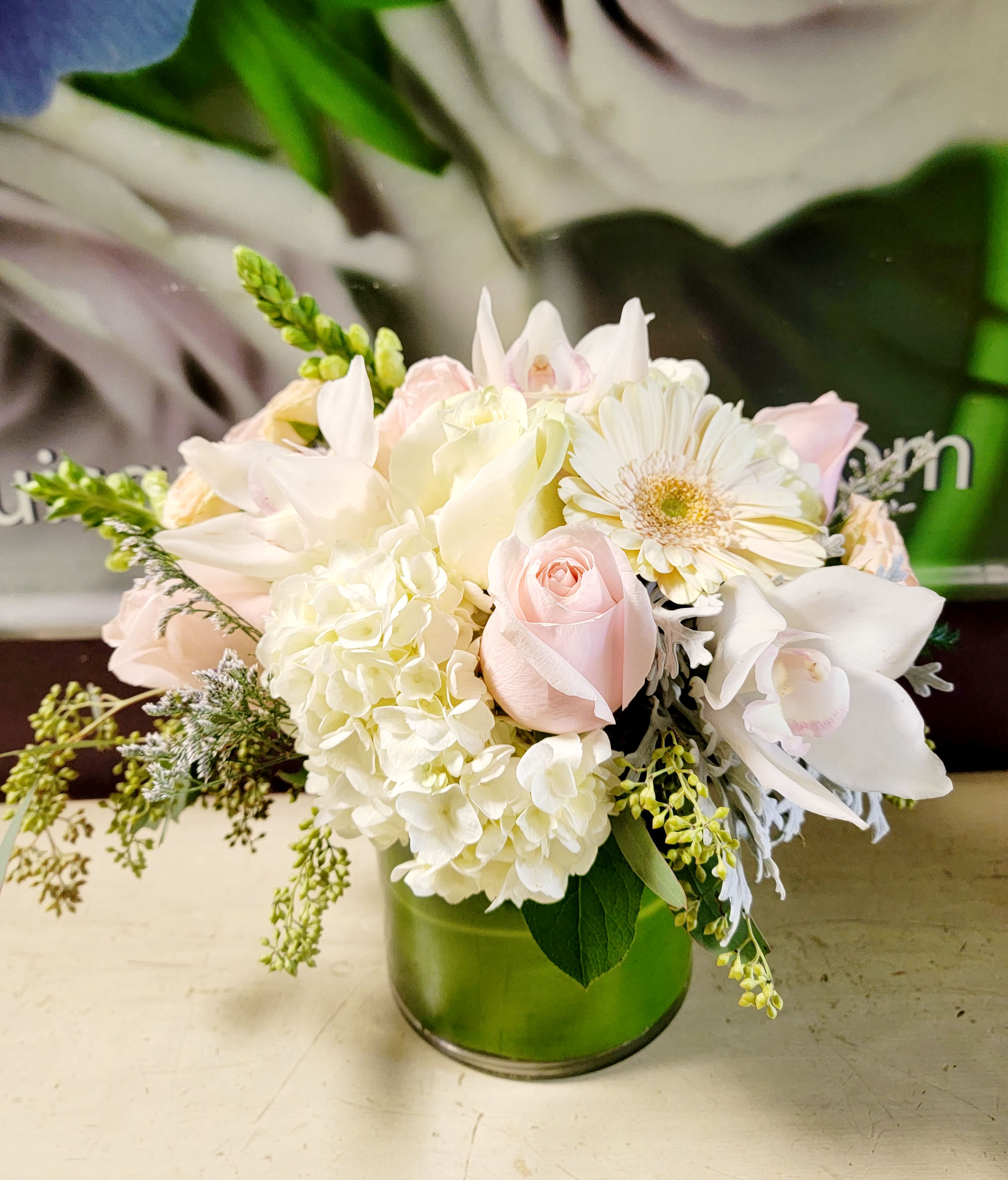 Soft pink and white bouquet in a green glass vase