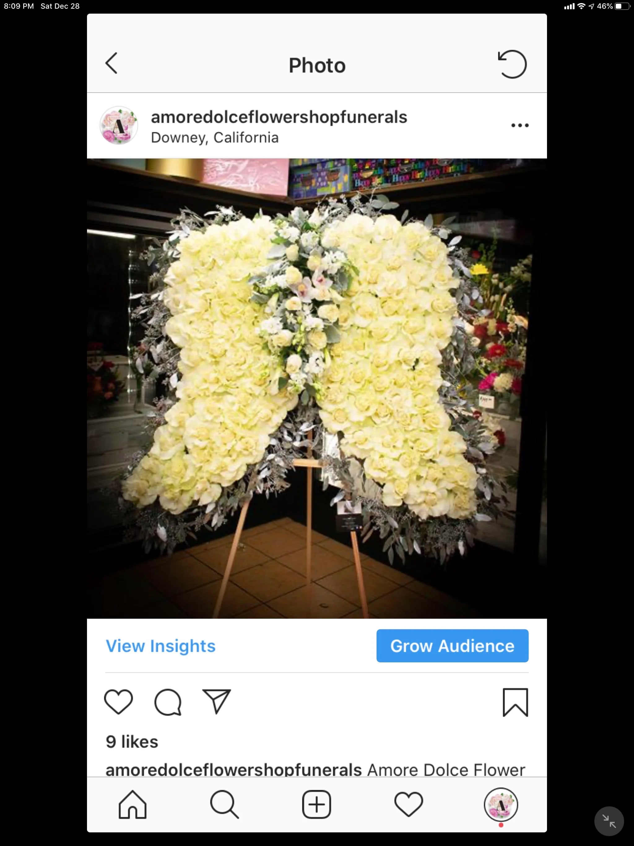 Large white floral funeral spray on an easel