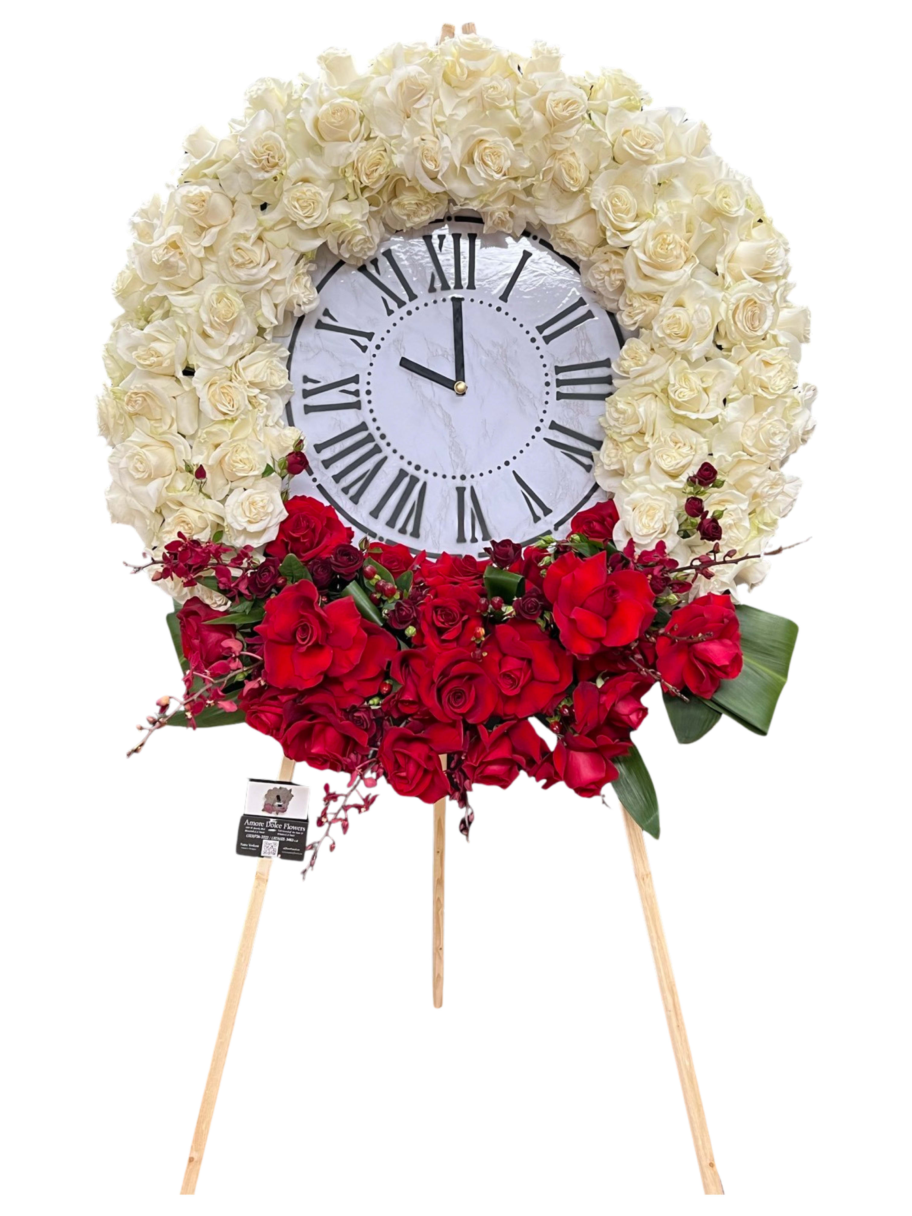 Time of Passing Tribute Arrangement - This elegant and meaningful floral clock arrangement symbolizes the passage of time and serves as a heartfelt tribute to honor a loved one’s life. Designed with pristine white roses representing peace and eternity, and vibrant red roses signifying love and remembrance, this piece is a timeless expression of respect and admiration.  Perfect for memorial services or funerals, the “Time of Passing Tribute Arrangement” beautifully conveys the message that while time on earth may come to an end, the love and memories shared will last forever.  Let us help you celebrate a life well-lived with this unique and poignant design.   Contact us today to create a custom arrangement for your loved one.  Let me know if you’d like any adjustments!