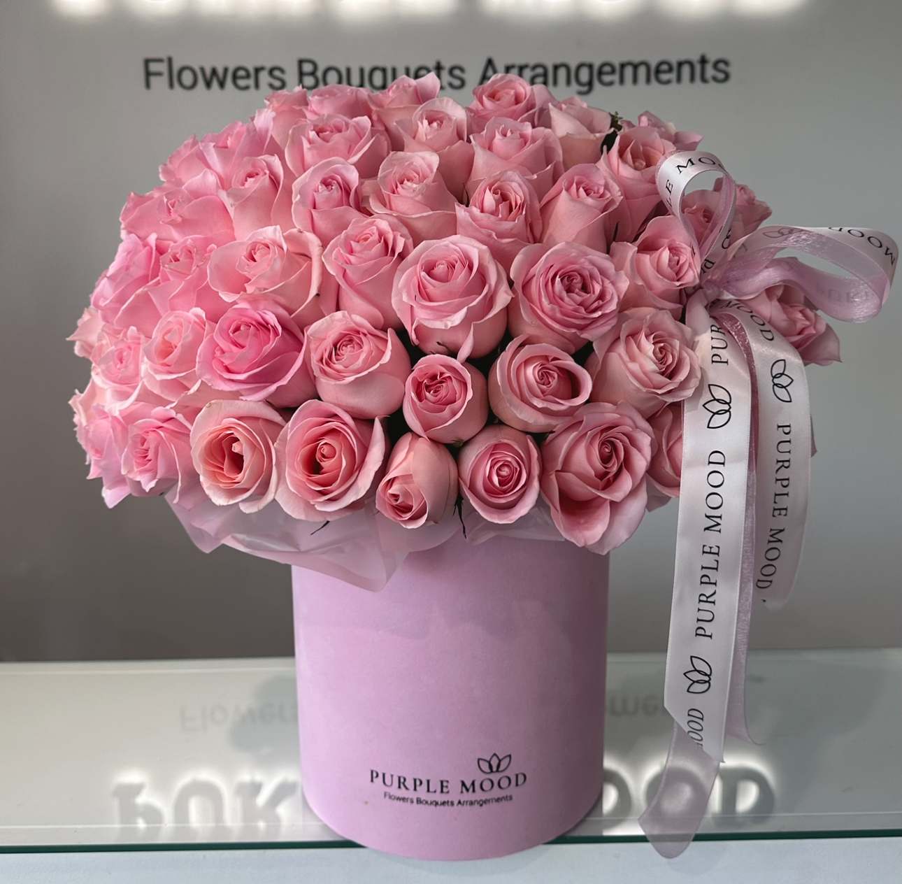50 Pink Roses In a Box - Size choices:  - STANDARD size - 50 roses (Container size D6.75'x H7.5') - DELUXE size - 75 roses (Container size D8.25'x H9.5') - PREMIUM size - 100 roses (Container size D10.5'x H12.25')  Romantic, elegant, and timeless — our 50 Pink Roses in Box arrangement is designed to leave a lasting impression. Hand-selected premium pink roses are carefully arranged in our signature velvet hatbox and tied with a satin ribbon for a refined, luxurious finish. The soft blush tones symbolize admiration, sweetness, and affection, making this the perfect gift for anniversaries, birthdays, or simply to brighten someone’s day.   •    50 premium long-stem pink roses     •    Arranged in a signature velvet hatbox with satin ribbon     •    Symbolizes admiration, grace, and gentle romance     •    Perfect for anniversaries, birthdays, Valentine’s Day, or milestone celebrations