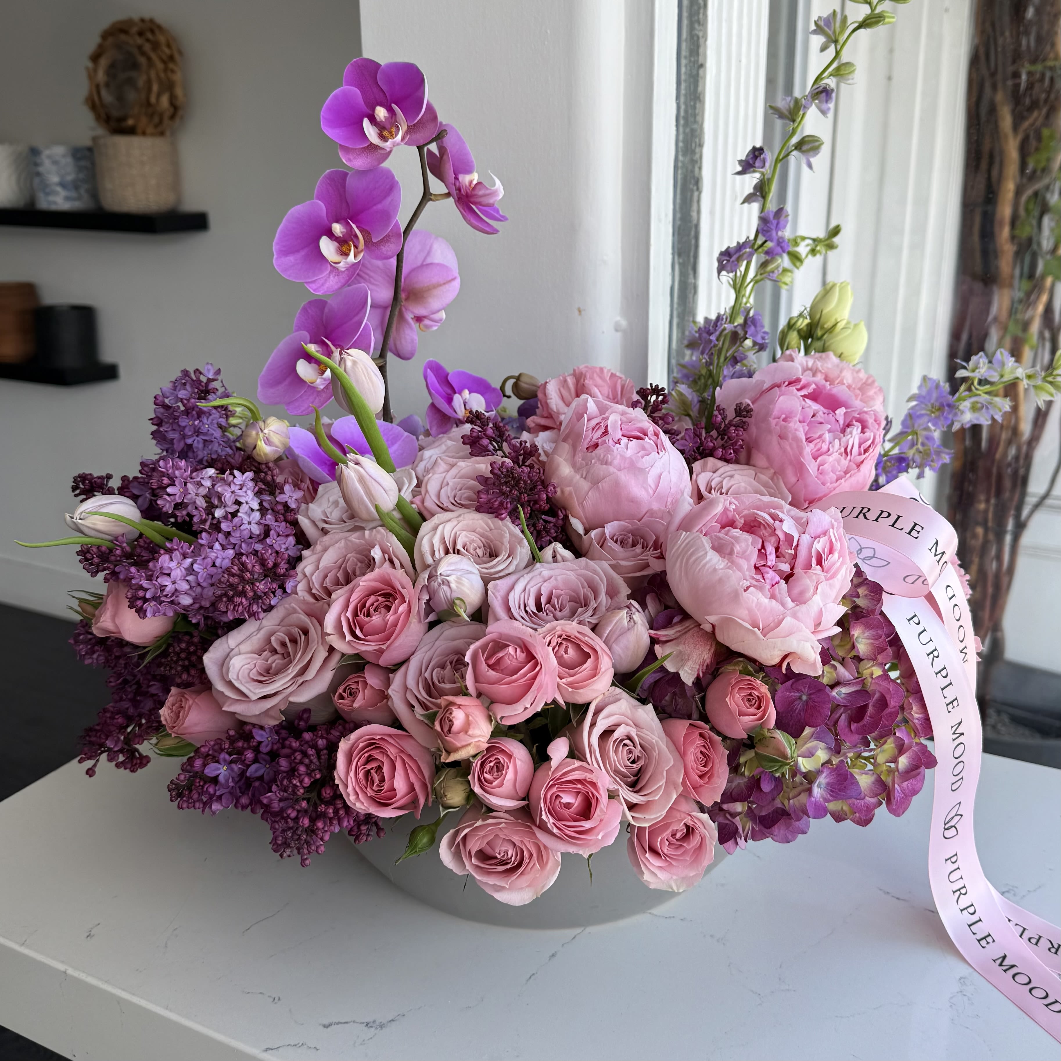 Vivien Vase - Vivien Vase The Vivien Vase is a breathtaking celebration of elegance and femininity. With a lush design full of soft pinks and vibrant purples, it creates a perfect harmony of romance and charm. Its graceful shape and rich color palette make it a luxurious gift that leaves a lasting impression.      •    Elegant mix of romantic tones     •    Designed in a wide, stylish vase     •    Full and abundant composition for a luxurious look     •    Perfect for anniversaries, birthdays, or as a grand romantic gesture