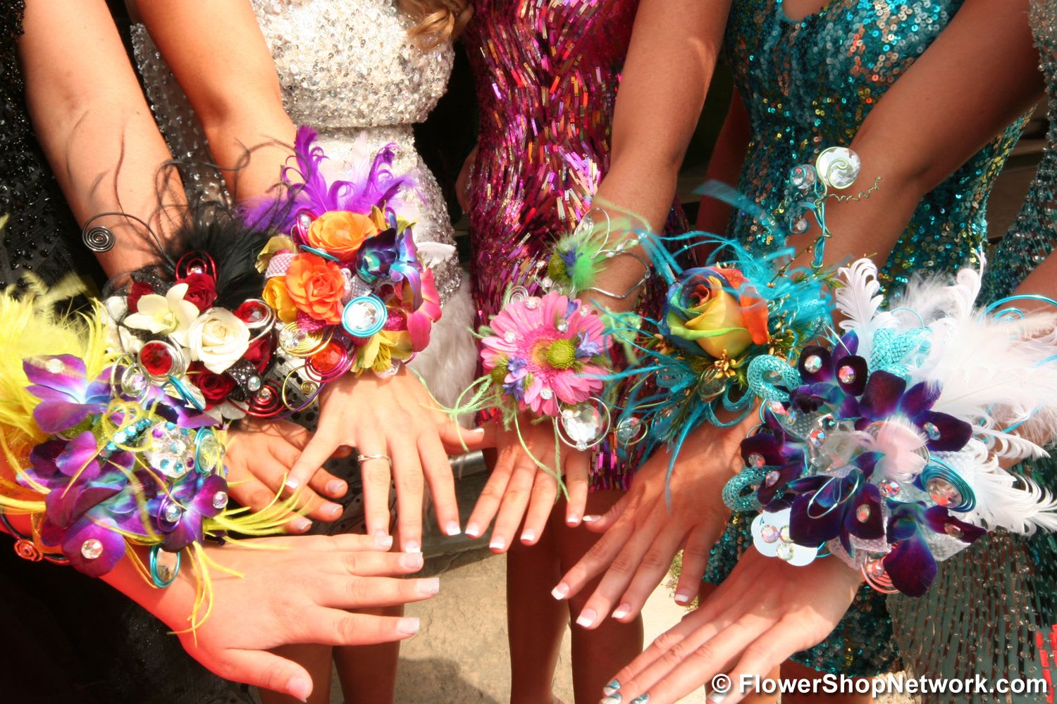 Colorful floral wrist corsages worn by several people