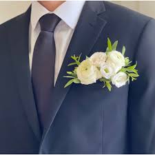 White boutonniere pinned to a navy suit jacket