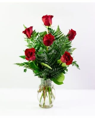 Red roses arranged in a clear glass vase