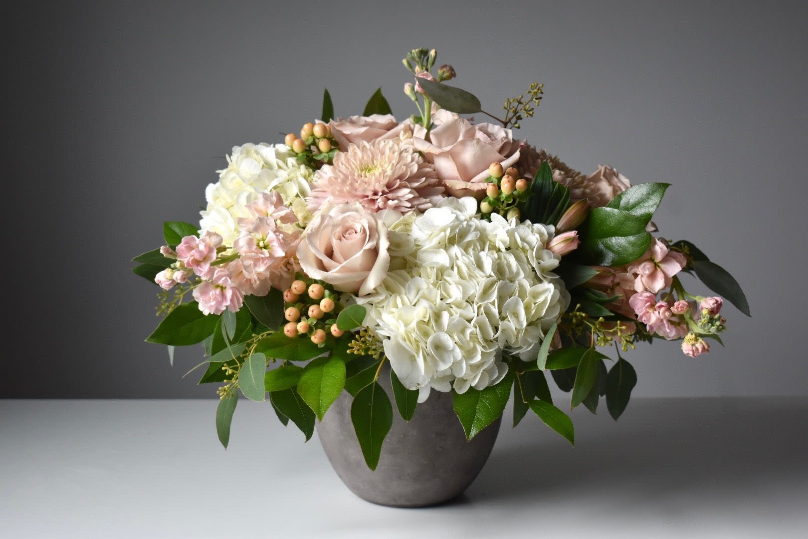 Blush roses and white hydrangeas in a gray vase
