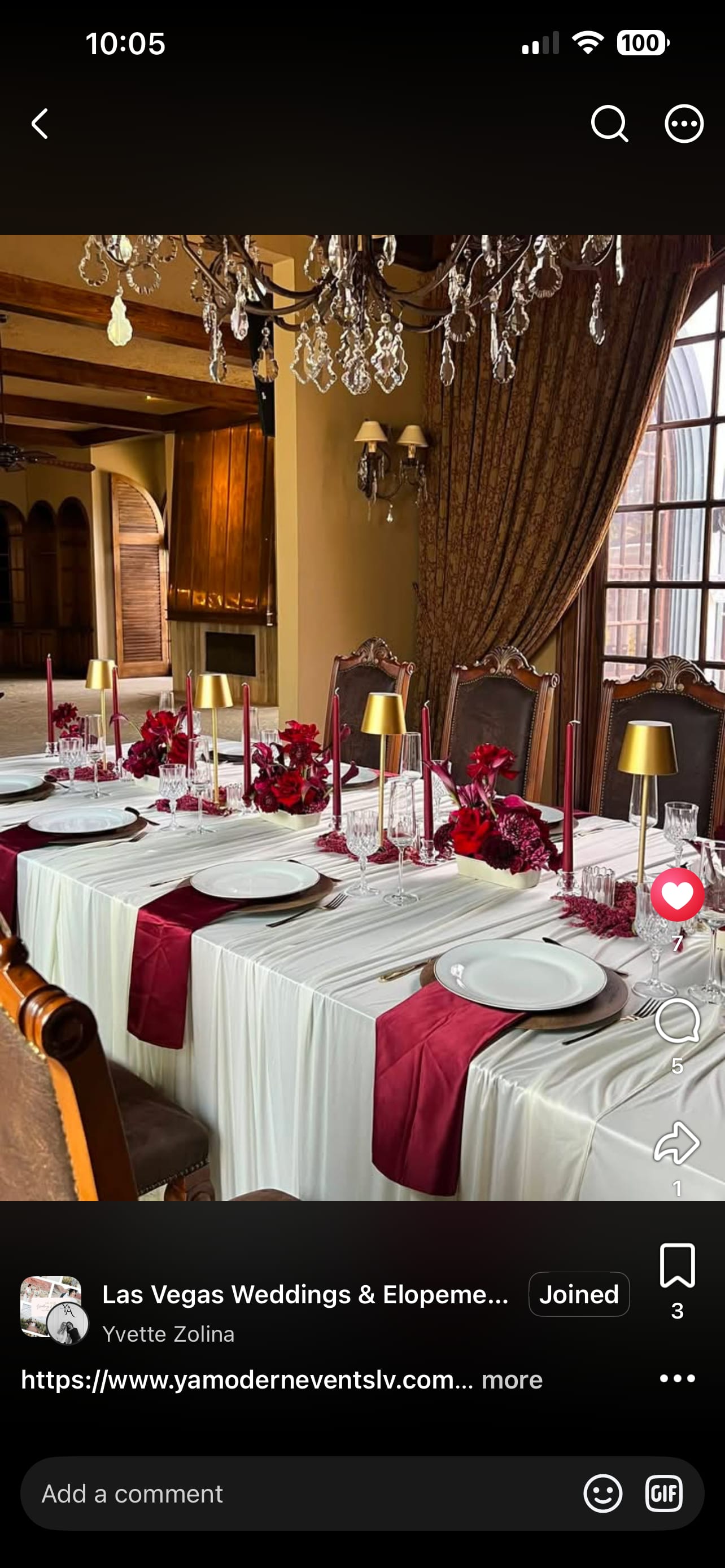 Wedding reception table with red floral centerpieces and gold candle holders