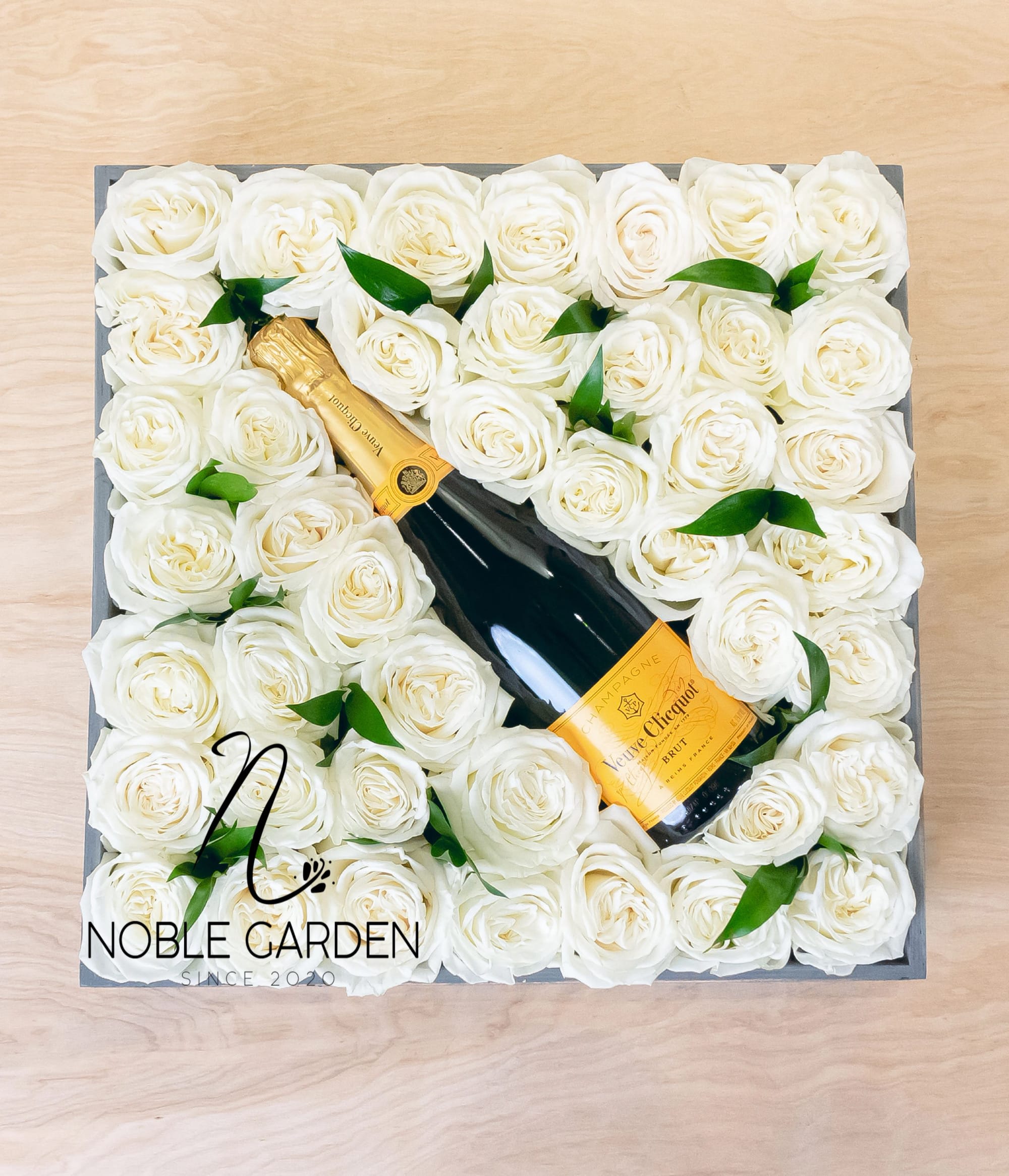 Box of white roses with a champagne bottle in the center