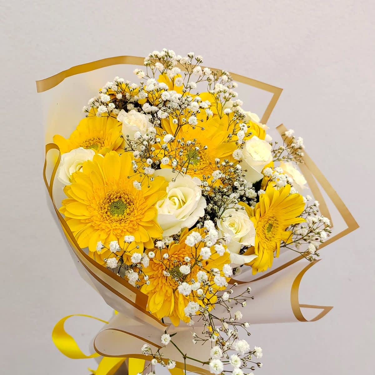 Bouquet of yellow gerbera daisies and white roses with baby's breath