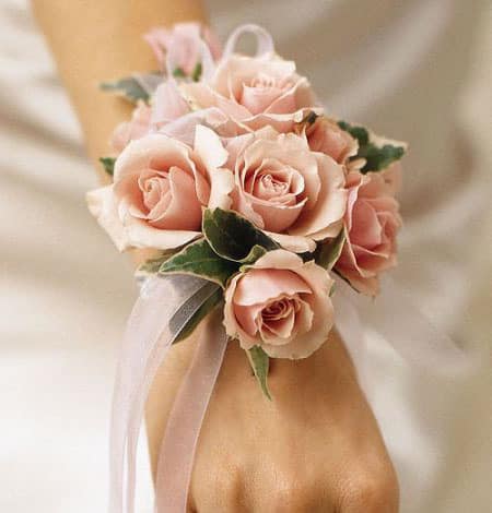 Pink rose wrist corsage with ribbon on a wrist