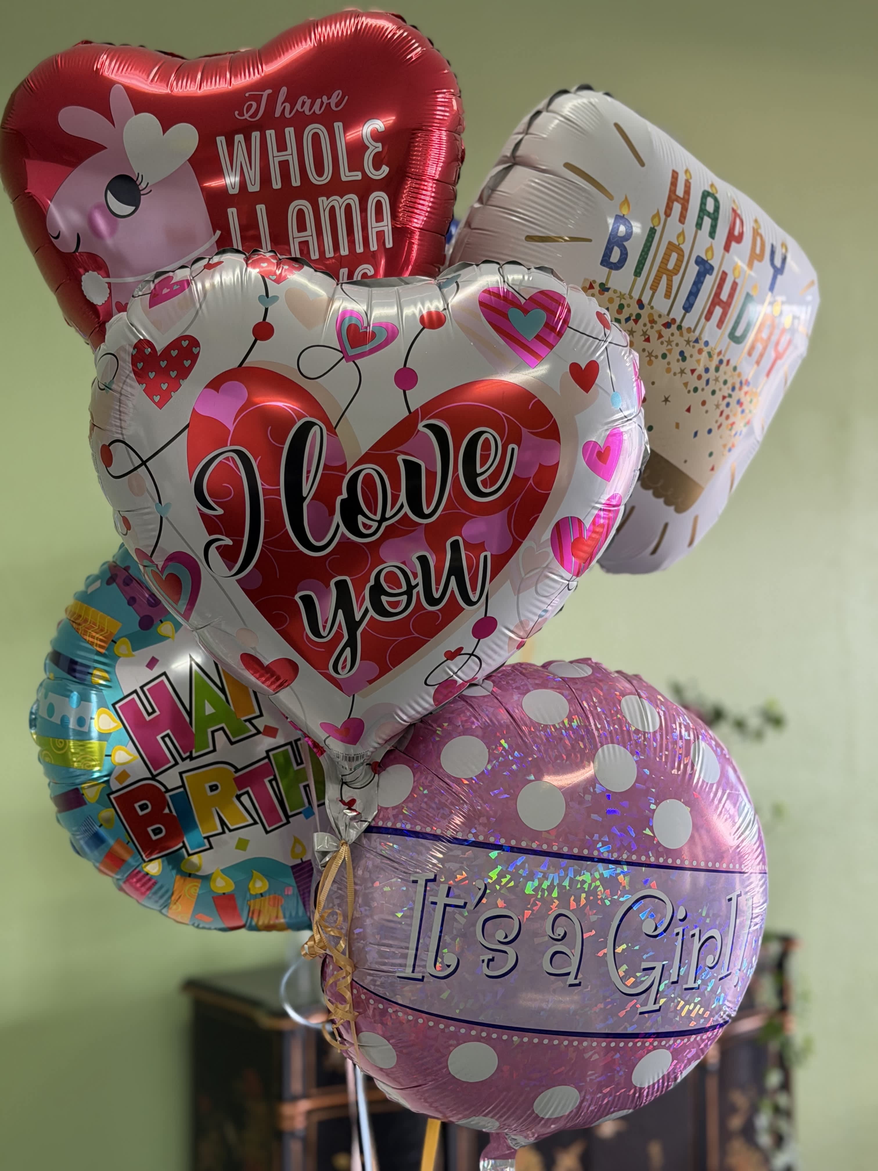 Cluster of birthday and love-themed foil balloons