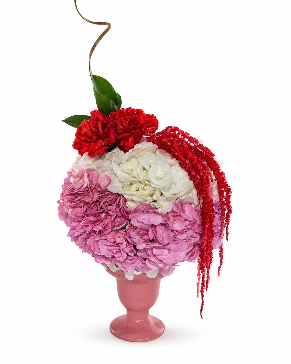 Pink and white floral arrangement in a pink vase with red accents