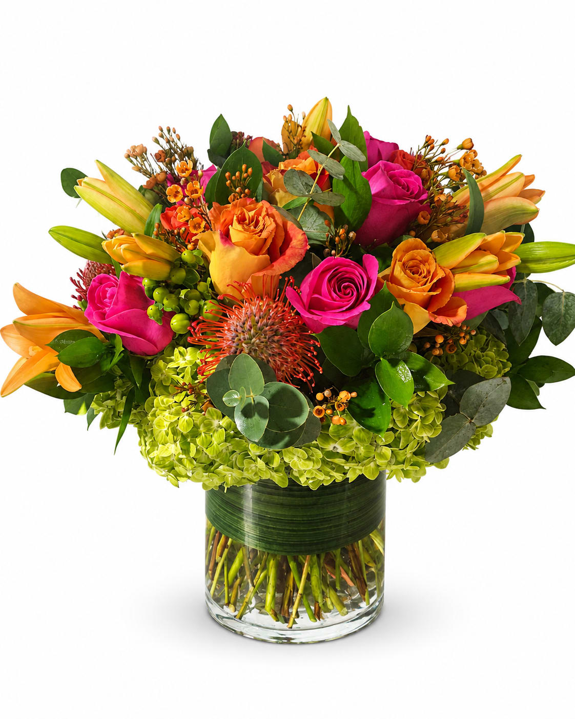 Bright mixed bouquet of roses and lilies in a glass vase
