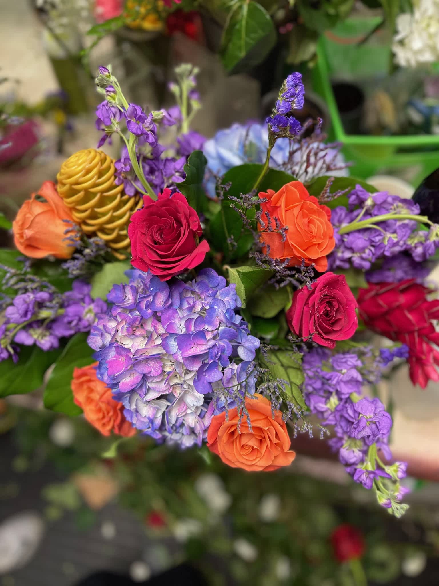 Bouquet of roses, hydrangea, and purple blooms in bright mixed colors