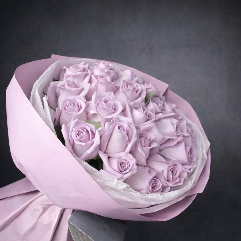Bouquet of pale lavender roses wrapped in pink paper