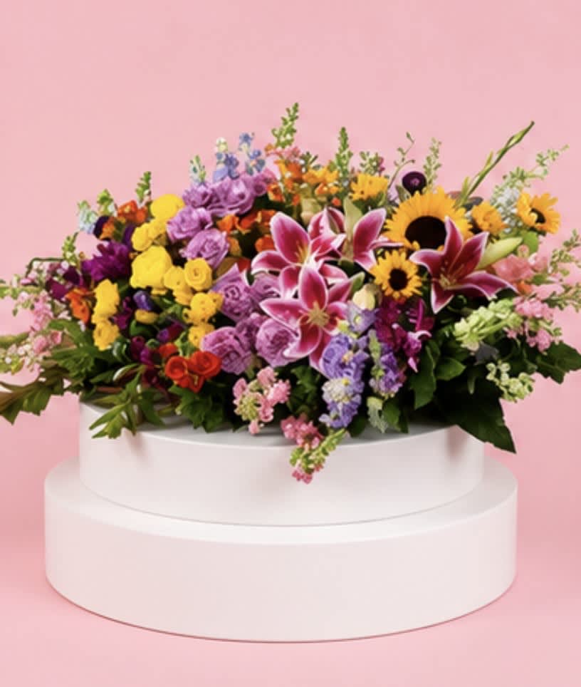 Colorful mixed flower arrangement in a white round container