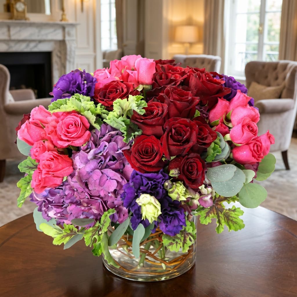 Bouquet of red, pink, and purple flowers in a clear glass vase