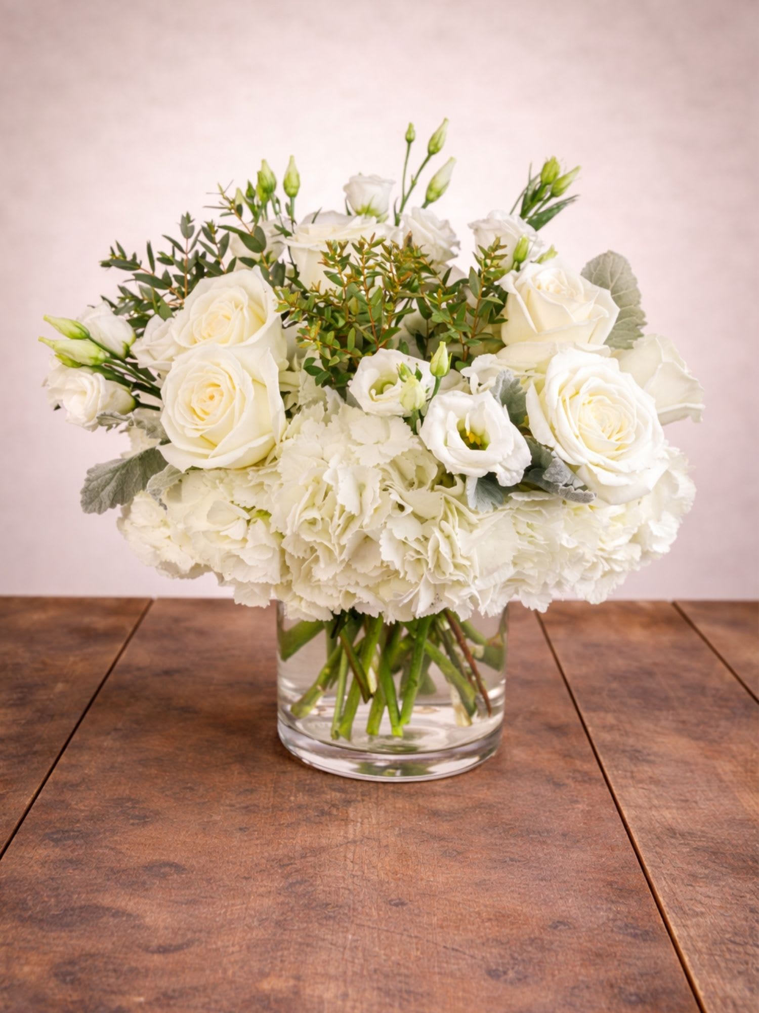 Cloud Nine White Roses BloomNation™ - Cloud Nine White Roses Arrangement is an elegant floral design featuring fresh white roses, soft white carnations, and lush greenery, handcrafted by Floral Fabulous and available for same-day flower delivery in Round Rock, Texas.  This graceful arrangement showcases creamy white roses nestled among delicate carnations and fresh greenery, beautifully arranged in a modern glass vase. The soft neutral tones create a peaceful and sophisticated design that complements any home or occasion.  Perfect for sympathy flowers, thoughtful thank-you gifts, elegant celebrations, or simply sending a message of comfort and care.  Each arrangement is designed fresh by the floral artists at Floral Fabulous and is available for same-day flower delivery in Round Rock and surrounding communities.