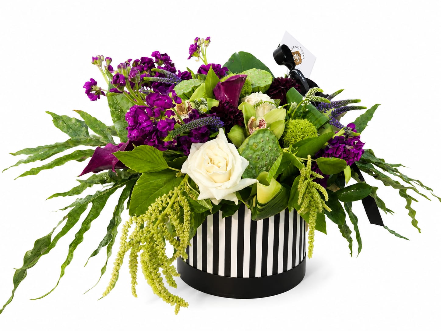 Purple and white floral arrangement in a striped round box