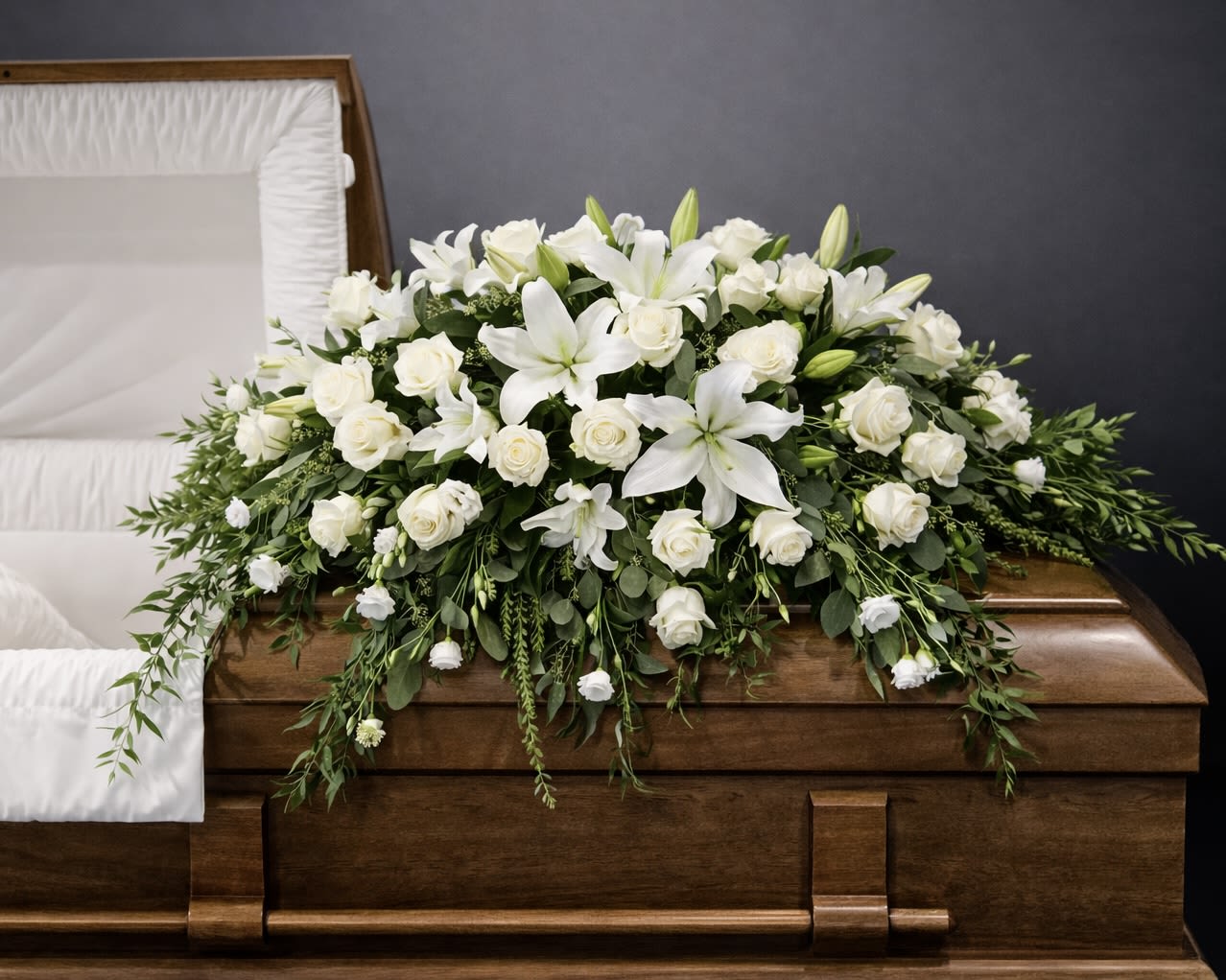 White floral casket spray with lilies and roses
