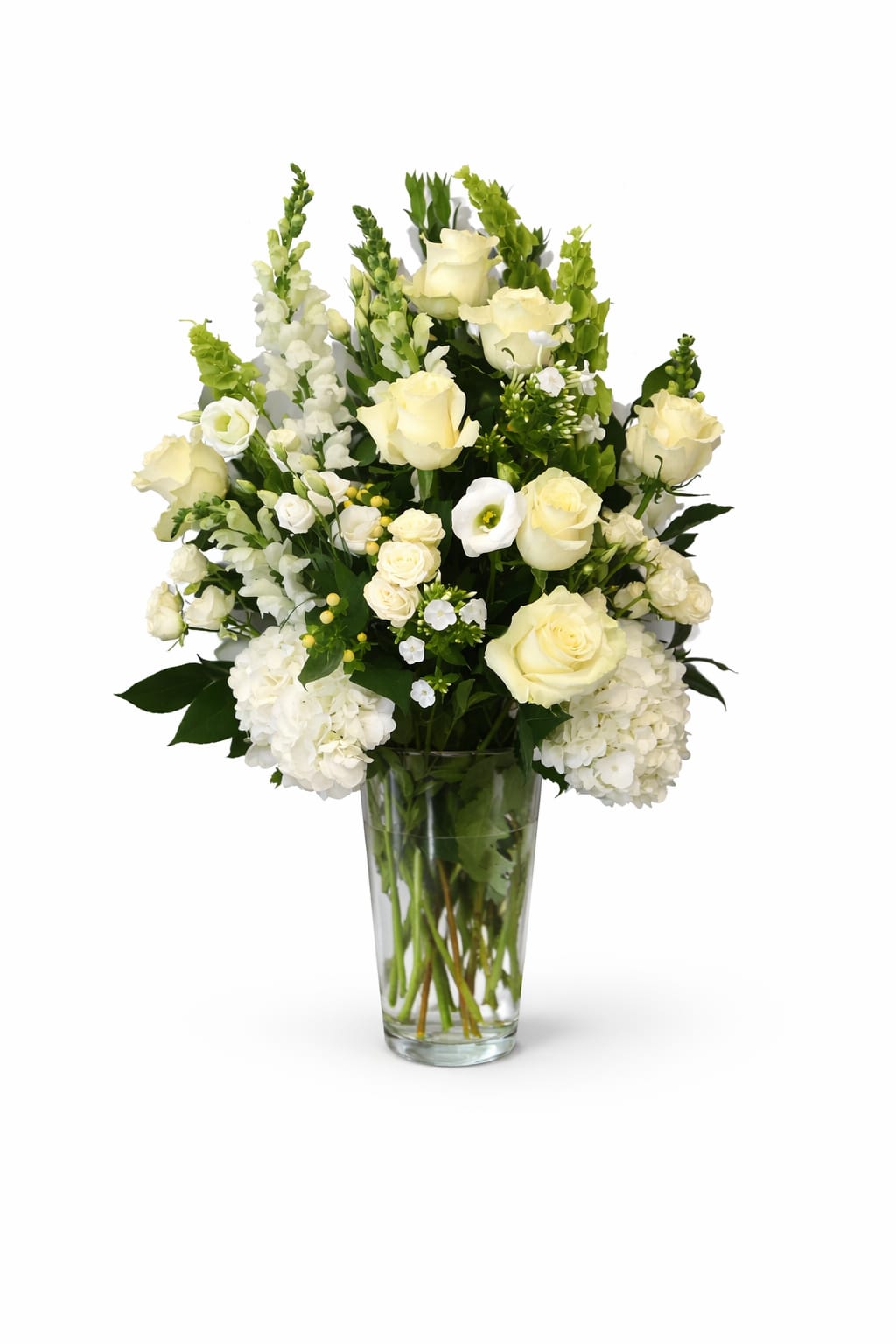 White roses and hydrangeas arranged in a clear glass vase
