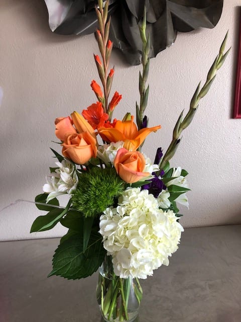 Orange roses and white hydrangea in a glass vase