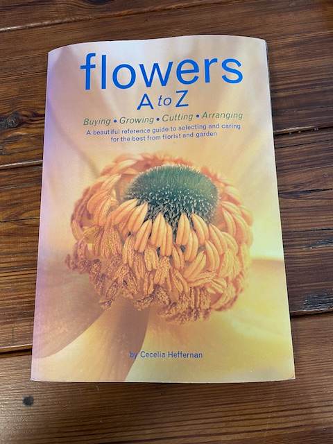 A book titled "flowers A to Z" on a wooden surface