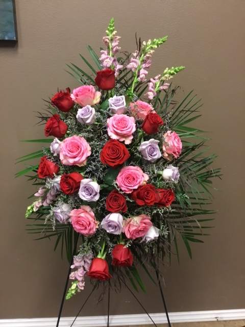 Standing floral spray of red, pink, and lavender roses