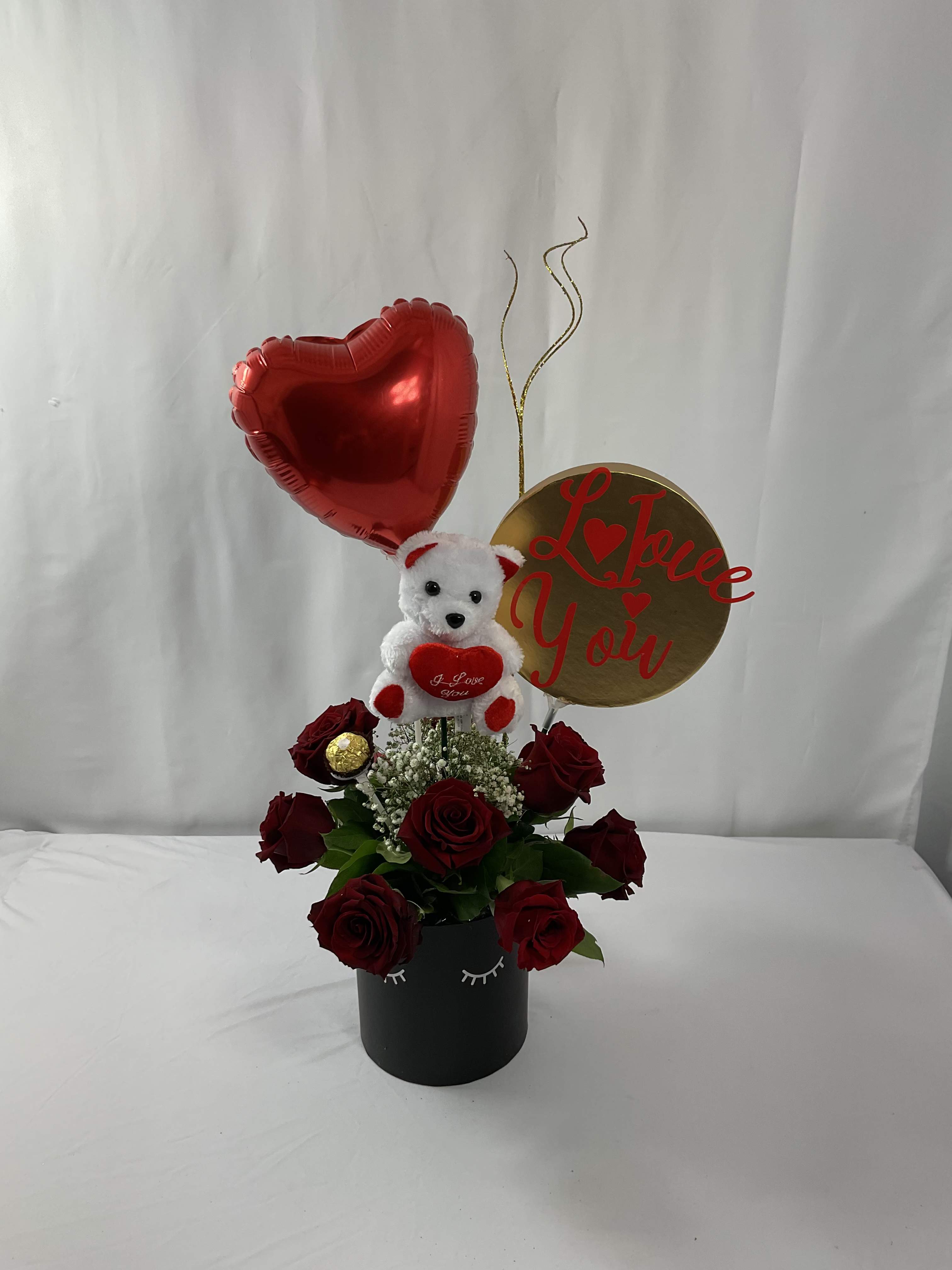 Red roses in a black box with a teddy bear and heart balloon