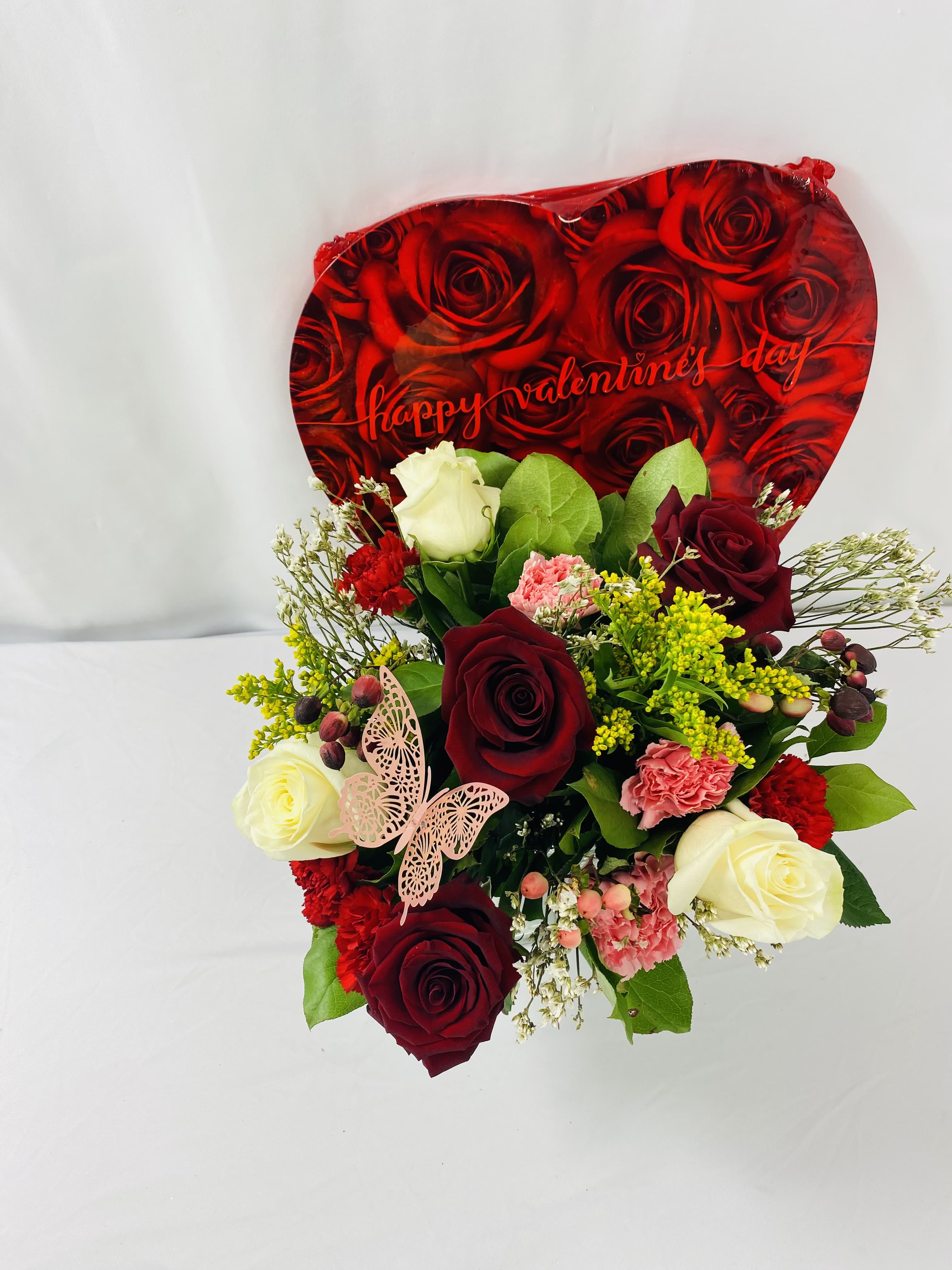 Bouquet of red and white roses with carnations and a Valentine card